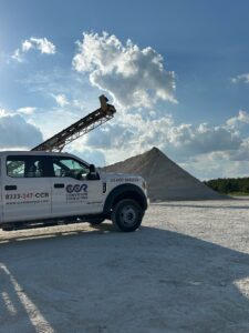 A CCR truck on a jobsite with a conveyor belt needing repair