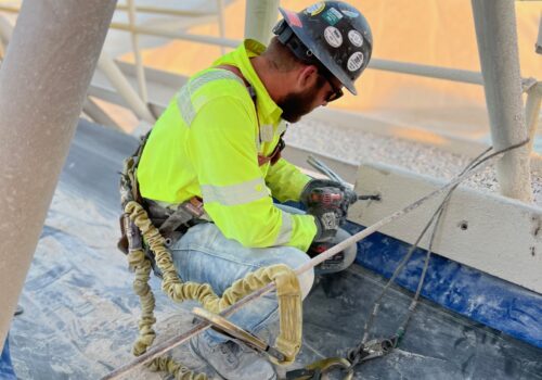 A technician helping perform repairs on a conveyor belt system