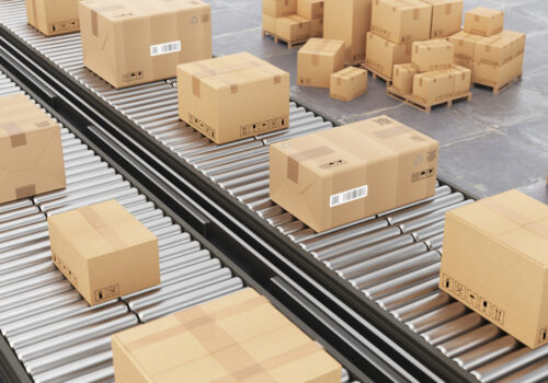Boxes are being transported on a conveyor belt in a spacious warehouse in Puerto Rico